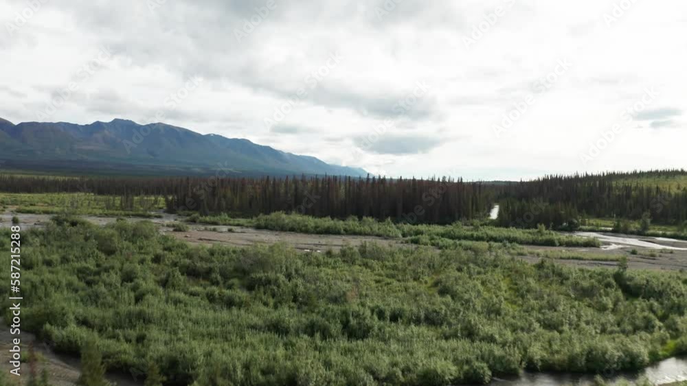 Cantwell River in Alaska during summertime, with a stunning backdrop of mountains, a picturesque bridge, and lush green wilderness. Cantwell River in Alaska during summertime, with a stunning backdrop of mountains, a picturesque bridge, and lush green wilderness.