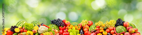 Fresh healthy vegetables, fruits, berries on green background.
