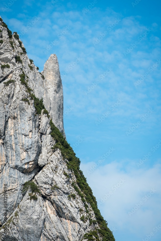 Vertical shot of a mountain with a blue sky in the background