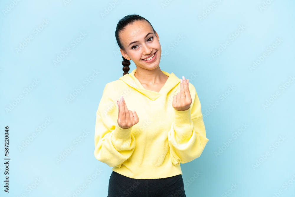 Young Arab woman isolated on blue background making money gesture Young Arab woman isolated on blue background making money gesture