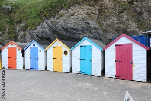 several different colored beach huts are next to each other in a row © Mikeglidephotography/Wirestock Creators