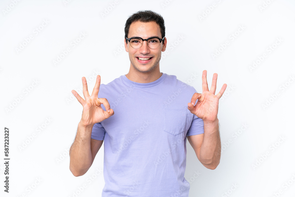 Young caucasian man isolated on white background showing ok sign with two hands Young caucasian man isolated on white background showing ok sign with two hands
