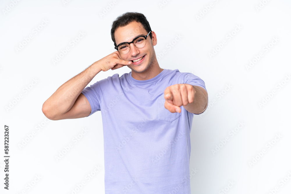 Young caucasian man isolated on white background making phone gesture and pointing front Young caucasian man isolated on white background making phone gesture and pointing front