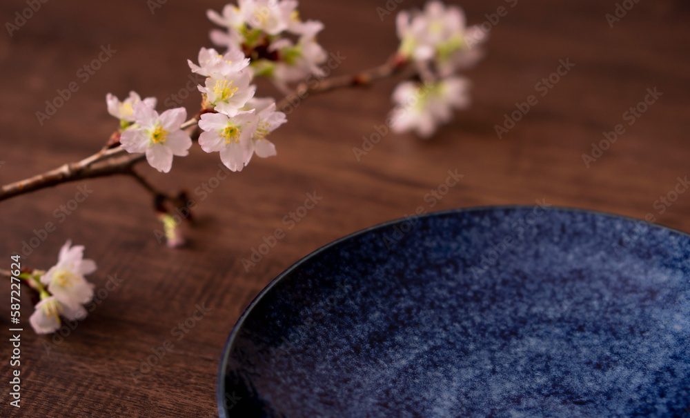 Spring dining table or cafe. Plate and cherry branch on the table. 春の食卓またはカフェ。テーブルの上のお皿と桜の枝 Spring dining table or cafe. Plate and cherry branch on the table. 春の食卓またはカフェ。テーブルの上のお皿と桜の枝