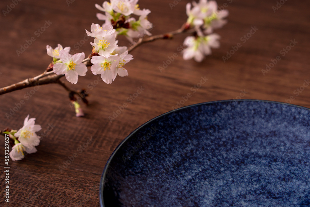 Spring dining table or cafe. Plate and cherry branch on the table. 春の食卓またはカフェ。テーブルの上のお皿と桜の枝 Spring dining table or cafe. Plate and cherry branch on the table. 春の食卓またはカフェ。テーブルの上のお皿と桜の枝