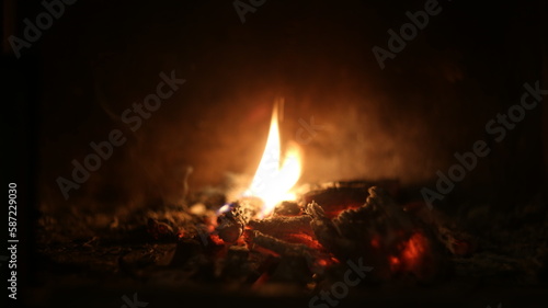The lash of flames, fire, hot coals in the fireplace, dark background