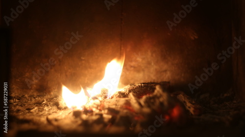 The lash of flames, fire, hot coals in the fireplace, dark background