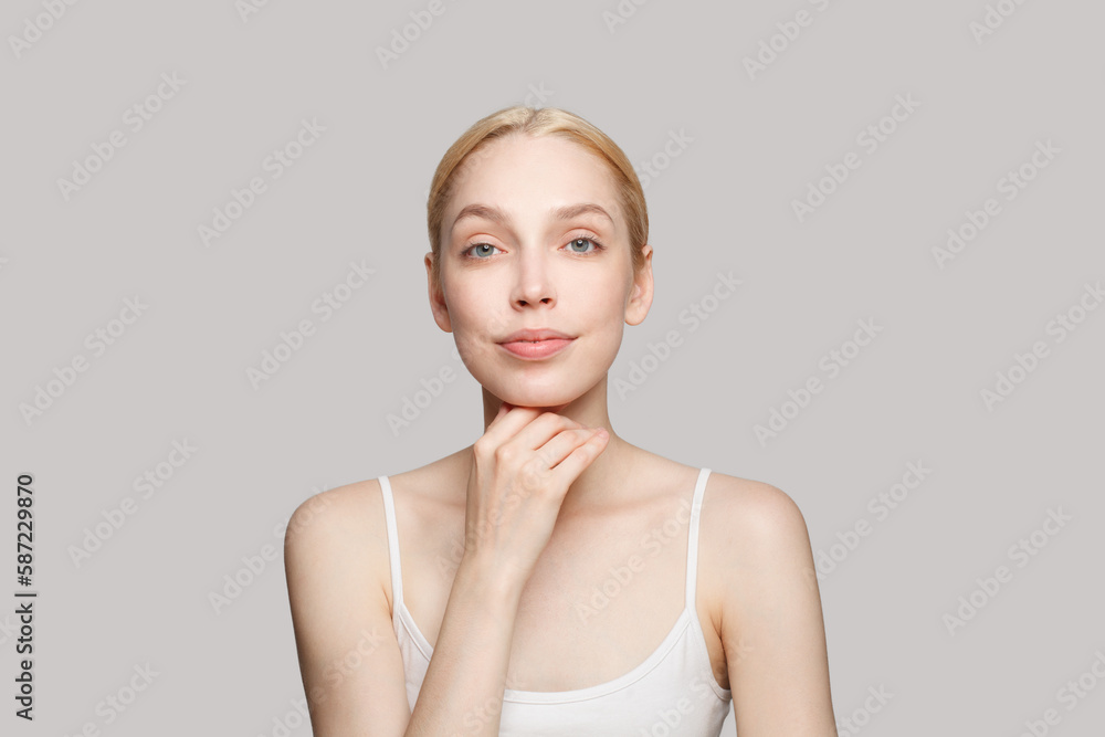 Pleased beautiful woman with blonde ponytail isolated on grey background. Beauty, cosmetics, skincare, glamour Pleased beautiful woman with blonde ponytail isolated on grey background. Beauty, cosmetics, skincare, glamour