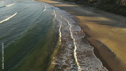 Drone View of Family Playing At Beach In Uruguay, Playa Grande Beach - Dolly Backwards Shot photo