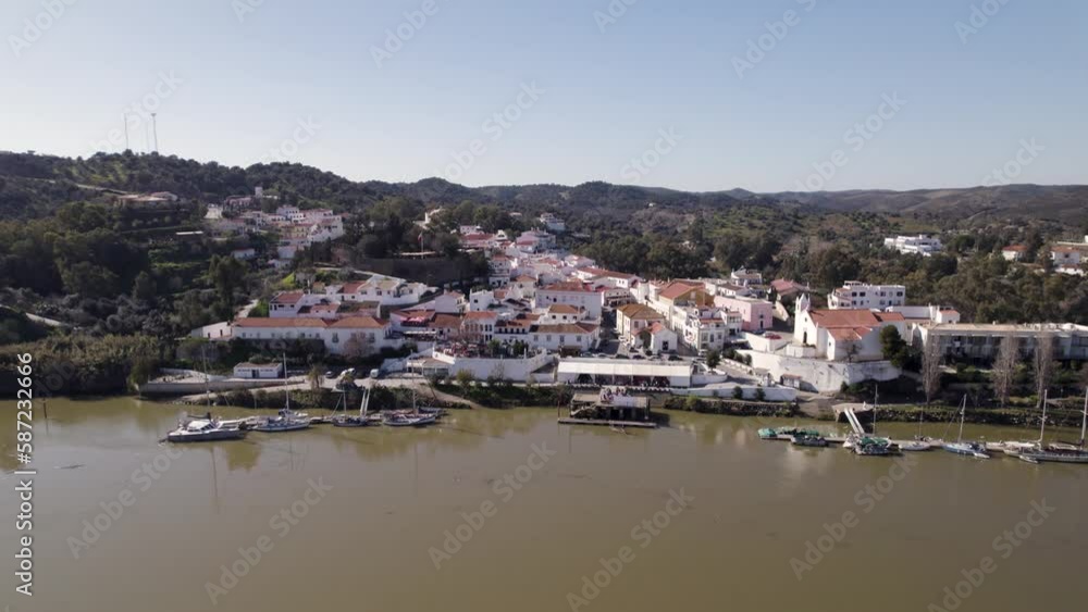 Aerial drone shot of Alcoutim, Portugal, featuring white houses along the Guadiana River. Aerial drone shot of Alcoutim, Portugal, featuring white houses along the Guadiana River.