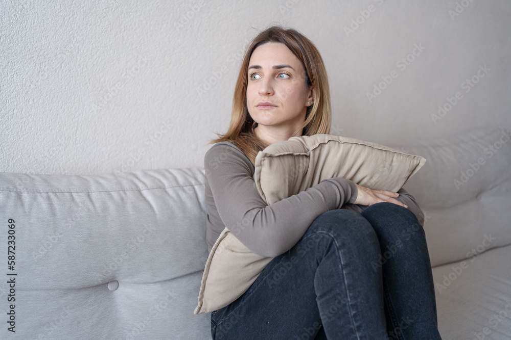 young attractive woman sitting at home living room couch tired and worried suffering depression feeling sad. young attractive woman sitting at home living room couch tired and worried suffering depression feeling sad.