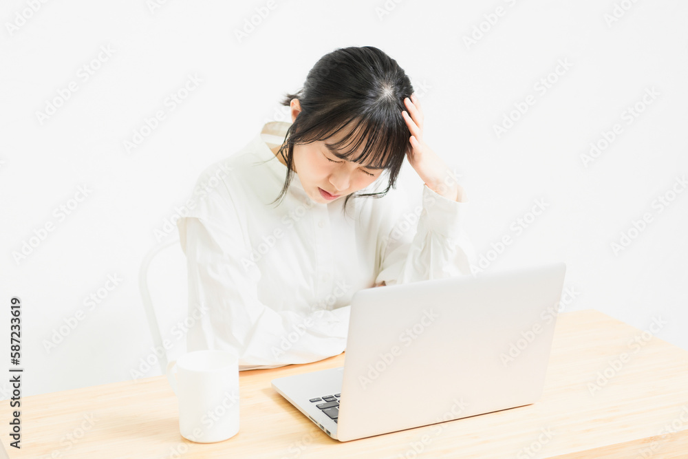 PCの前で悩んでいる若い女性 PCの前で悩んでいる若い女性