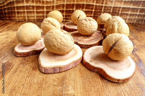 Walnuts lie on wooden saw cuts. Old wooden background