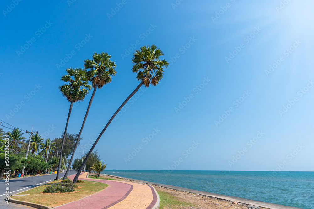 Obraz premium Three palm trees and the beach landmark of Pranburi, Prachuap Khiri Khan,Thailand, A place for tourists and a beautiful beach.take a souvenir photo