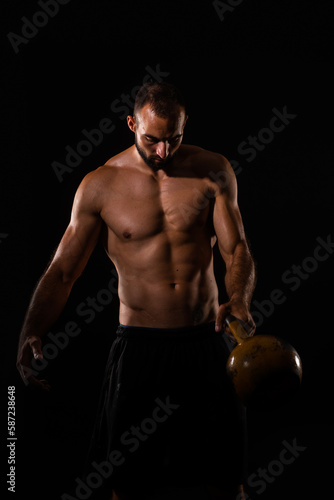 Handsome guy is about to put the dumbbell down to take a break