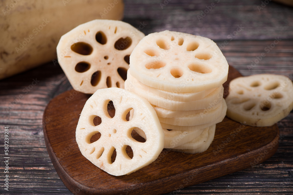 Fototapeta premium fresh raw lotus root slices on wooden table