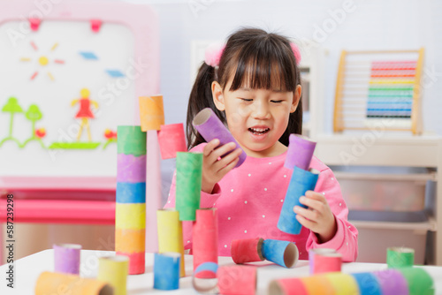young girl was making colorful craft at home