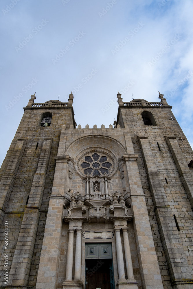 Entrada principal de la catedral de Burgos con los campanarios a los lados y su gran vidriera en el centro bajo un cielo nublado.