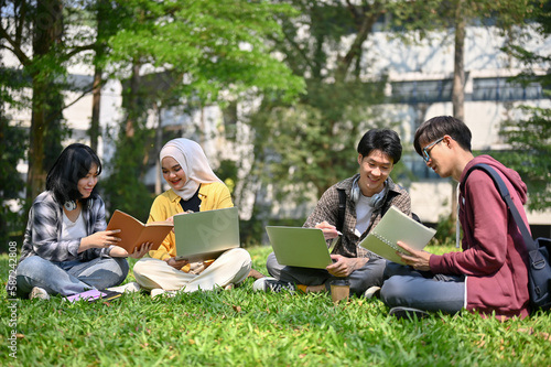 A group of smart young Asian-diverse college students are in the campus park together.
