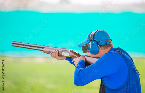 Clay pigeon shooting. An athlete shoots a gun at moving targets, sport gun shooting, clay pigeon shooting. Training process at the shooting range. photo