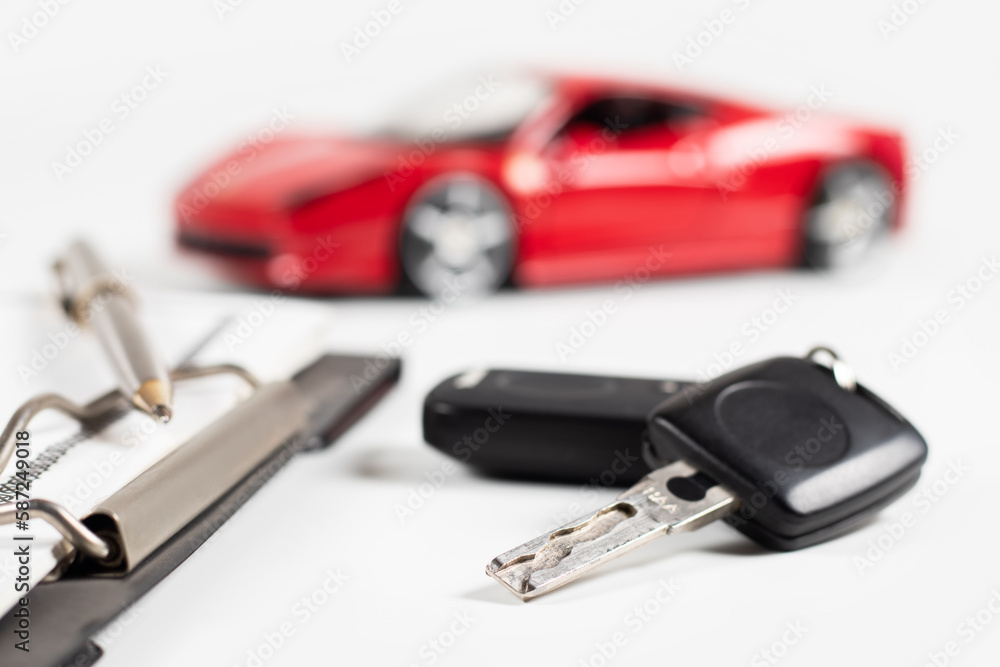 Car insurance form, pen and key on wooden table, and red car background Car insurance form, pen and key on wooden table, and red car background