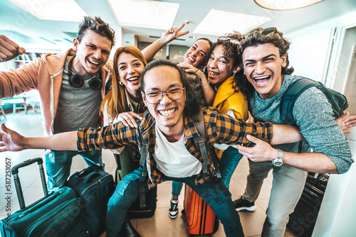 Group of young tourists standing in youth hostel guest house - Happy multiracial friends booking summer vacation home - Guys and girls having fun taking selfie picture at summertime holidays photo