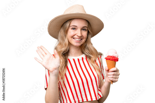 Young English woman with a cornet ice cream over isolated background saluting with hand with happy expression photo