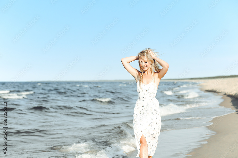 Happy blonde beautiful woman having fun on ocean beach while dancing in waves Happy blonde beautiful woman having fun on ocean beach while dancing in waves