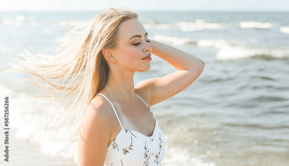 Happy blonde woman in free happiness bliss on ocean beach standing straight and posing Happy blonde woman in free happiness bliss on ocean beach standing straight and posing