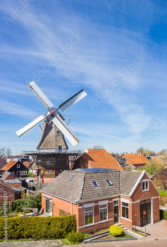 Historic windmill and typical dutch houses in Winsum, Netherlands