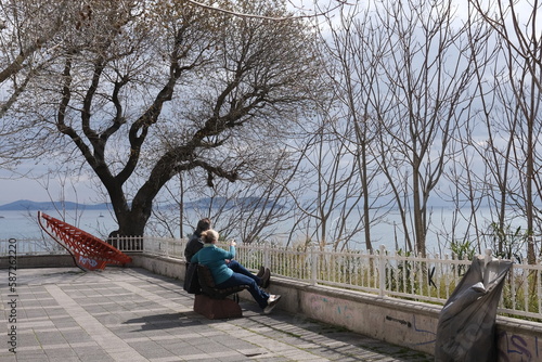 people are resting on a bench under a tree