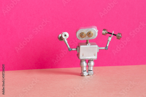 Silver toy Robot athlete weightlifter holding a dumbbells. Sport fitness, weightlifting and power lifting athletics workouts. copy space on blue green background.