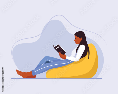 girl sitting on a chair (ottoman) with a book