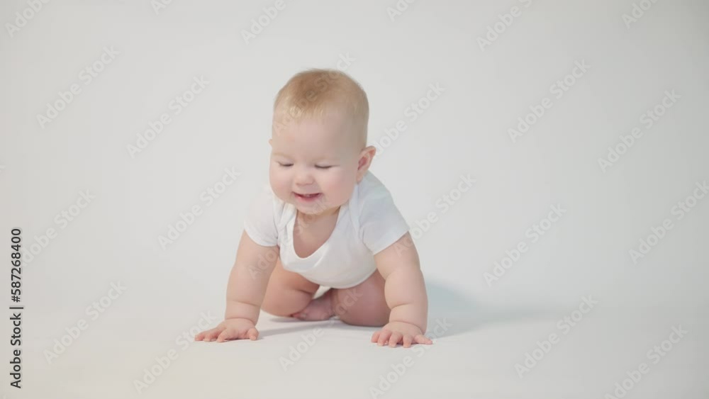 infant on white background first attempts to crawl on his knees infant on white background first attempts to crawl on his knees