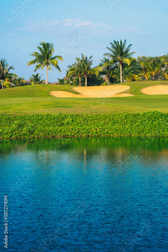 A golf course with palm trees in the background