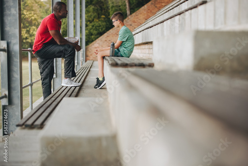 Bilde på lerret Coach motivating a sad school kid outdoors