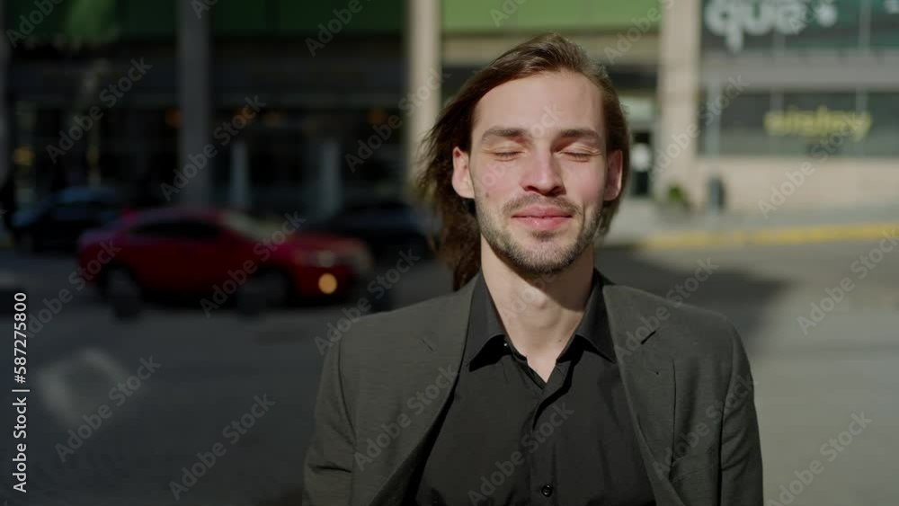 Portrait handsome man in coat looking at camera stand outdoors on background stairs. Sunlight at city street. Slow motion Portrait handsome man in coat looking at camera stand outdoors on background stairs. Sunlight at city street. Slow motion