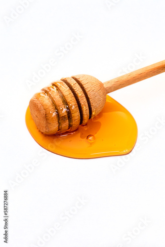 Honey with honey dipper isolated on white