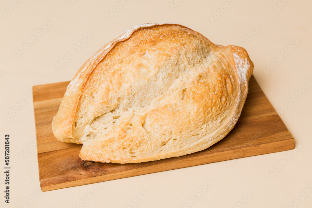 Freshly baked bread on cutting board against white wooden background. perspective view bread with copy space Freshly baked bread on cutting board against white wooden background. perspective view bread with copy space