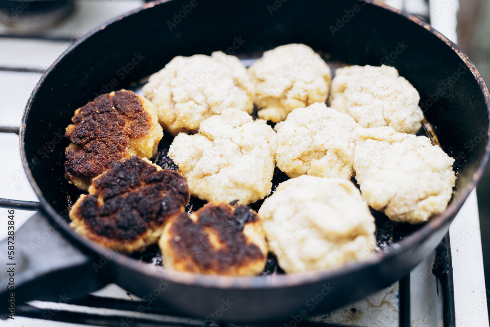 Raw pork cutlets are fried in an old soviet frying pan. Raw pork cutlets are fried in an old soviet frying pan.