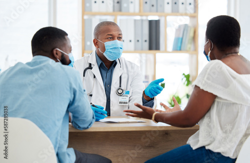 Covid, health and doctor consulting a black couple in a hospital for wellness, insurance or treatment. Medical, healthcare or trust with a medicine professional talking to a man and woman in a clinic © Nina/peopleimages.com