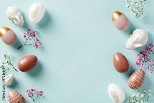 Happy Easter double border frame made of Easter eggs, bunnies, flowers on pastel blue background. Easter holiday greeting card template.