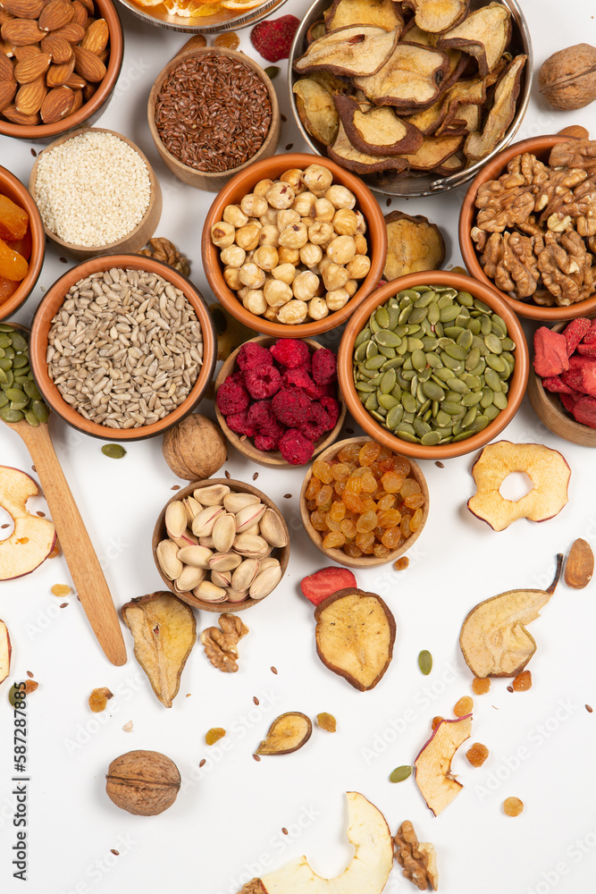 Healthy vegetarian food concept. Assortment of dried fruits, nuts and seeds on white background. Top view. Mixed nuts set closeup. Healthy vegetarian food concept. Assortment of dried fruits, nuts and seeds on white background. Top view. Mixed nuts set closeup.