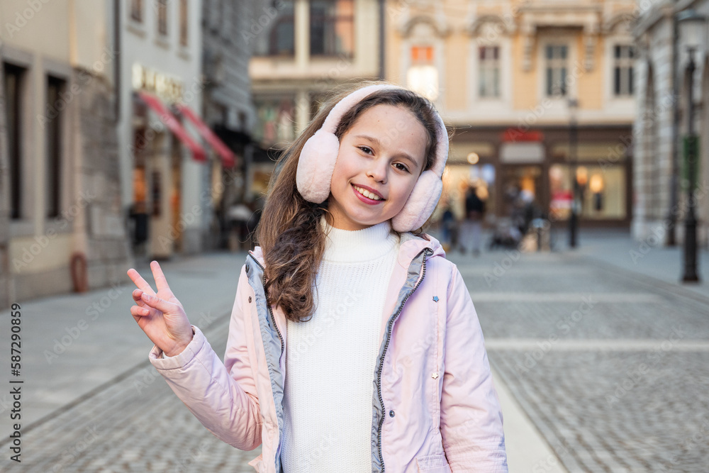 Child 10 year old girl smiling in sunny day looking at the camera, being cheerful and enjoying life in the city centre Child 10 year old girl smiling in sunny day looking at the camera, being cheerful and enjoying life in the city centre