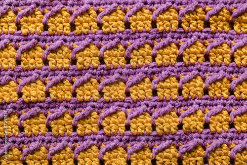 Yellow violet seamless knitted texture. Cross over stitch pattern. Volumetric crochet striped pattern. Knitted background. © Tanya