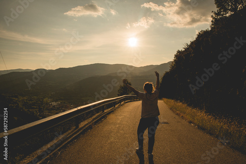 Chica en el medio de la carretera celebrando la libertad y relajada