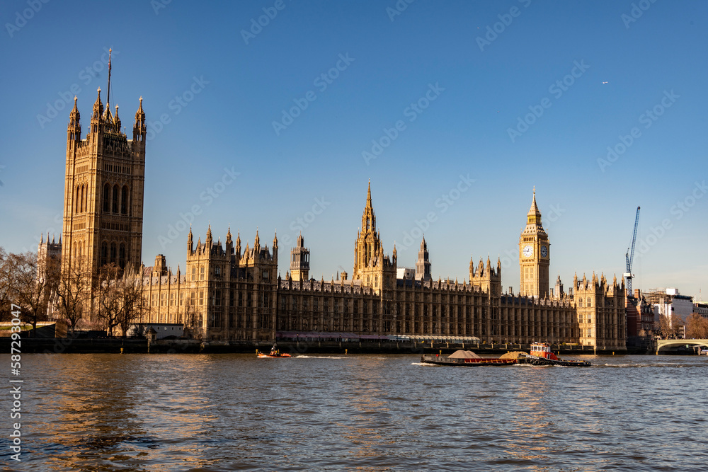 Big Ben and the River Thames with a blue sky and warm sunshine