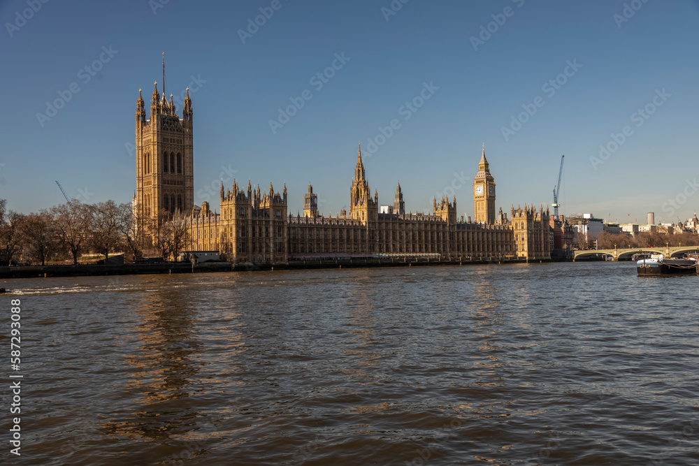 Big Ben and the River Thames with a blue sky and warm sunshine