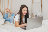 Close up portrait of a girl working at home on a laptop looking at the screen
