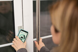 Woman hands using phone scan to digital door lock security systems at home